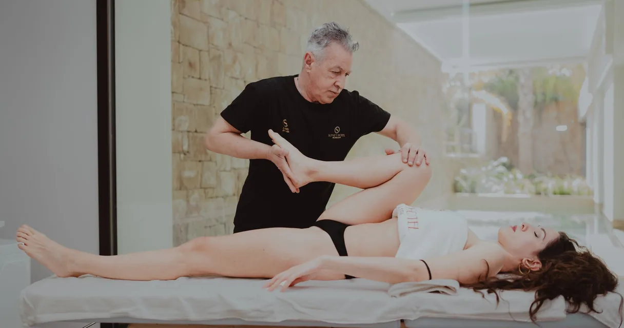 Fisioterapeuta fazendo terapia manual na perna de uma paciente