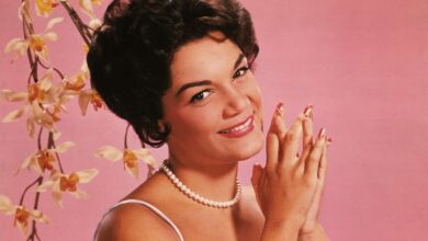 Studio portrait of American singer Connie Francis wearing a lavender and white spaghetti-strap dress.