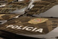 A imagem mostra a parte frontal de veículos da Polícia Civil, com o emblema da polícia visível. O capô dos carros é preto e apresenta a palavra