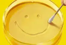 A yellow petri dish with a smile made by a cotton swab