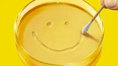 A yellow petri dish with a smile made by a cotton swab