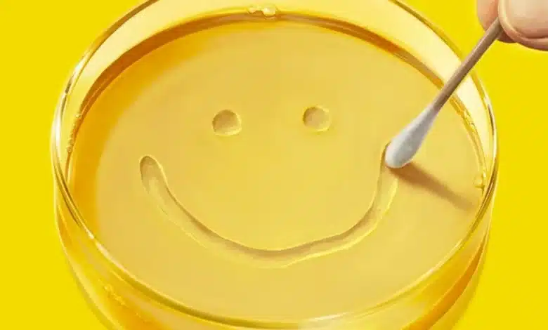 A yellow petri dish with a smile made by a cotton swab