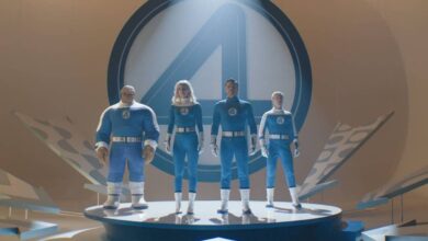 A imagem mostra quatro personagens em trajes azuis, em uma plataforma circular. Eles estão posicionados em uma pose heroica, com um grande símbolo do Quarteto Fantástico ao fundo. A iluminação destaca os personagens, criando um efeito dramático. O ambiente é moderno e minimalista, com elementos gráficos ao redor.