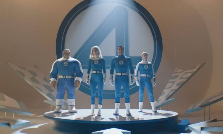A imagem mostra quatro personagens em trajes azuis, em uma plataforma circular. Eles estão posicionados em uma pose heroica, com um grande símbolo do Quarteto Fantástico ao fundo. A iluminação destaca os personagens, criando um efeito dramático. O ambiente é moderno e minimalista, com elementos gráficos ao redor.