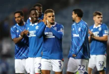 Max Aarons applauds the Rangers fans at the end of a game